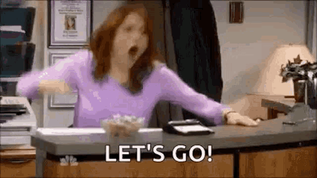 An image from The Office of a woman behind a desk screaming “Let’s go !”