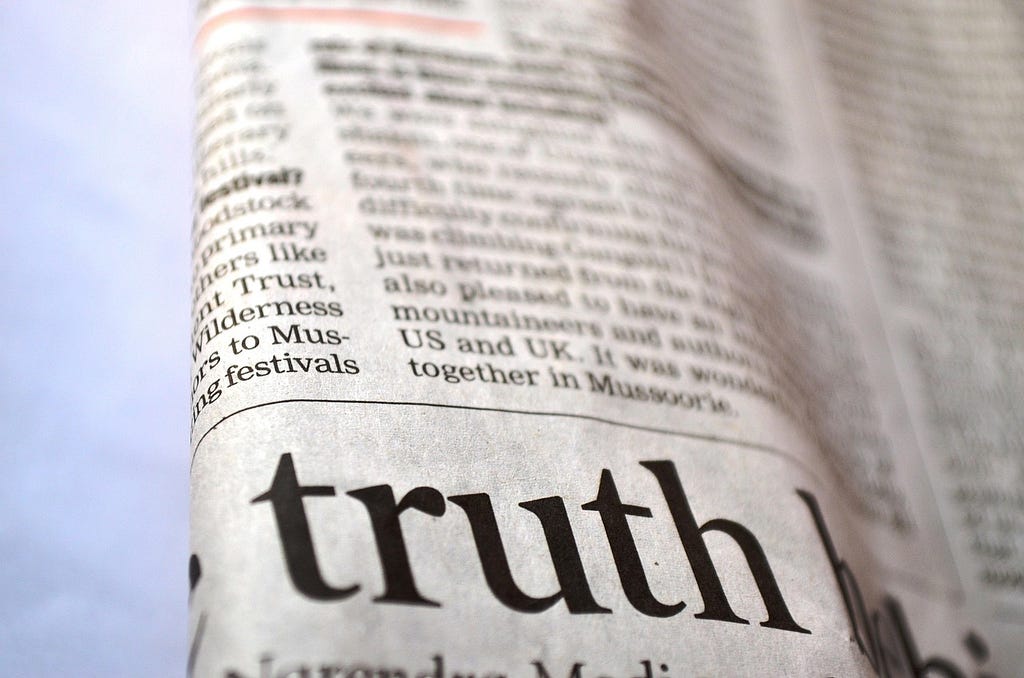 A picture of a newspaper with the word “truth” focused
