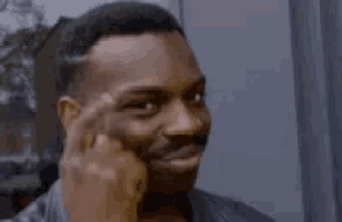 An image of a man pointing his finger on his head.
