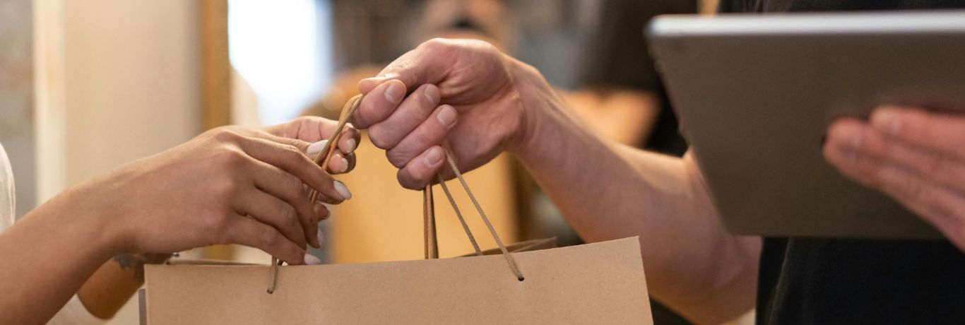 Mains tenant un sac papier craft et tablette